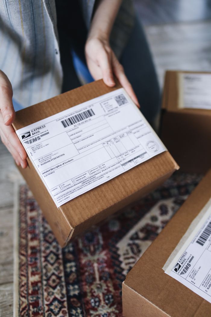 our-story Close-up of hands holding a package with a visible shipping label, perfect for delivery themes.